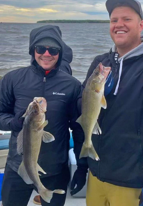 image of fishing charter customers holding walleyes caught on Lake of the Woods